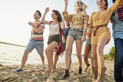 Happy friends walking at beach 