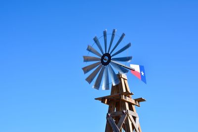 Low angle view of traditional windmill against clear blue sky