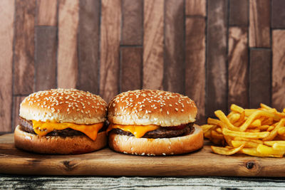 Close-up of hamburgers and french fries on wooden tray