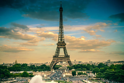 Eiffel tower in city against cloudy sky