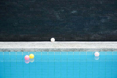 Balloons on wall by swimming pool