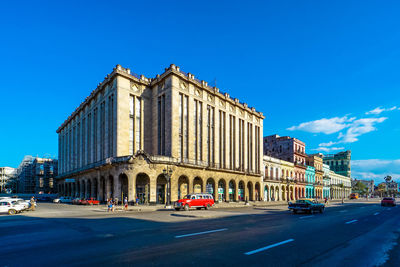 Low angle view of city street against clear blue sky