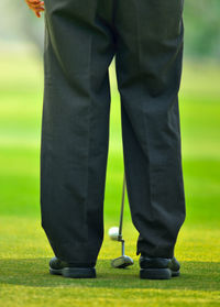 Low section of man standing on field