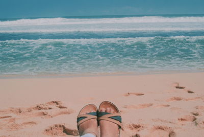 Low section of woman wearing sandals at beach