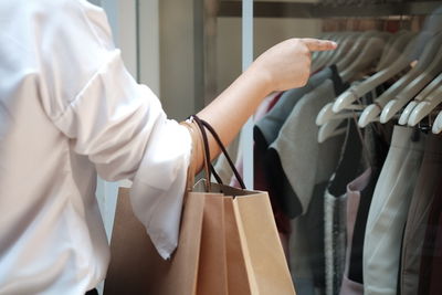 Midsection of man holding rack in store