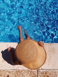 High angle view of woman wearing hat sitting at poolside