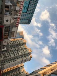 Low angle view of buildings against cloudy sky