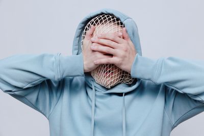 Midsection of woman wearing hat against white background