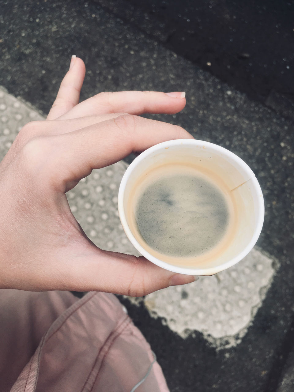 HIGH ANGLE VIEW OF HAND HOLDING COFFEE