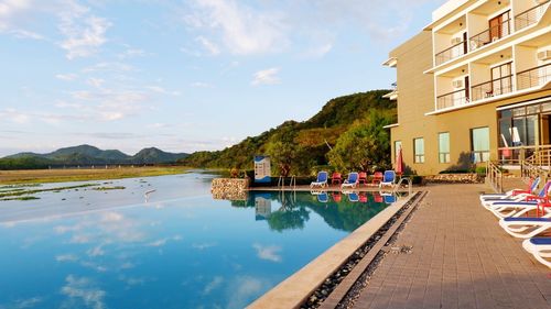 View of swimming pool by lake against sky