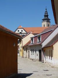 Houses by building against clear sky