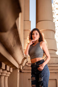 Young woman standing against wall