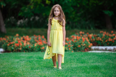 Portrait of a smiling young woman standing on grass