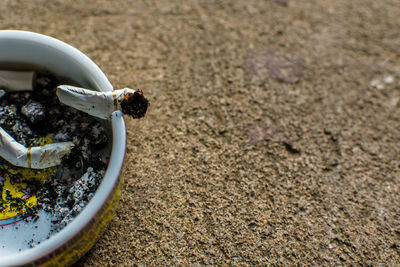 High angle view of cigarette butts in ashtray on table