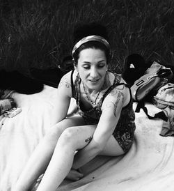 Portrait of a smiling young woman sitting on field