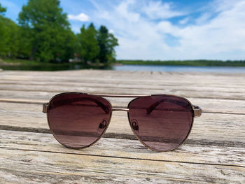 Close-up of sunglasses on beach against sky