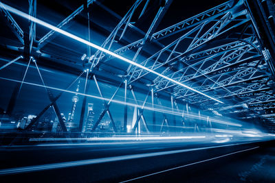 Low angle view of illuminated bridge in city at night