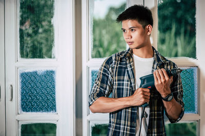 Young man looking through window