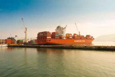 Commercial dock by sea against sky