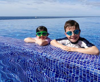 Portrait of smiling siblings in swimming pool