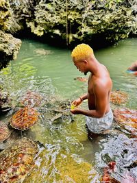 High angle view of boy playing in lake