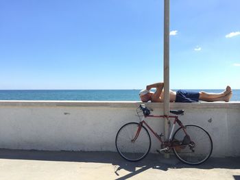 Bicycle on beach against clear blue sky