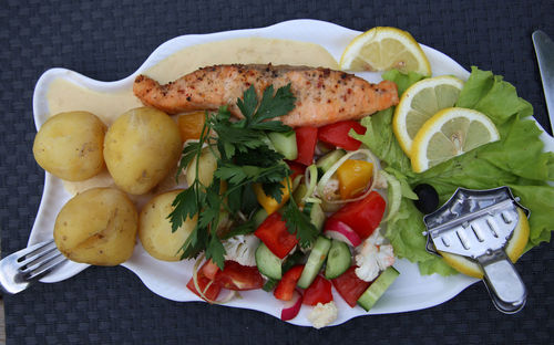 High angle view of salmon and salad in plate on table