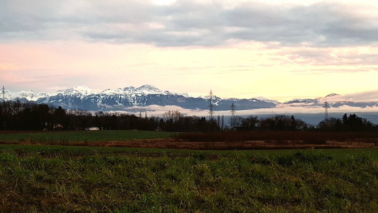 sky, tranquil scene, landscape, mountain, tranquility, scenics, beauty in nature, cloud - sky, field, grass, nature, mountain range, cloudy, cloud, non-urban scene, weather, idyllic, sunset, rural scene, growth