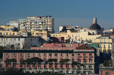 Buildings in city against clear sky