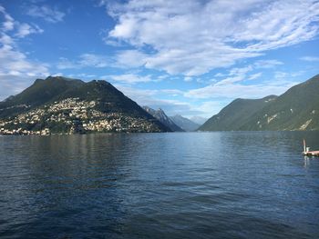 Scenic view of sea by mountains against sky