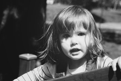 Close-up portrait of cute girl playing outdoors