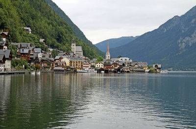 Houses by buildings in town against sky