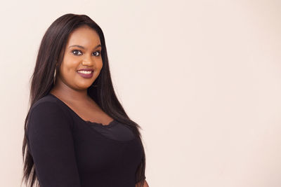 Portrait of smiling young woman against white background