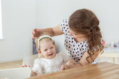 Portrait of cute baby girl sitting on table