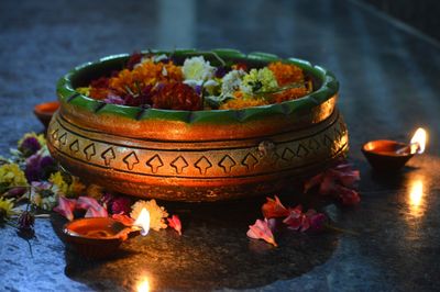 Close-up of lit candles on flowers