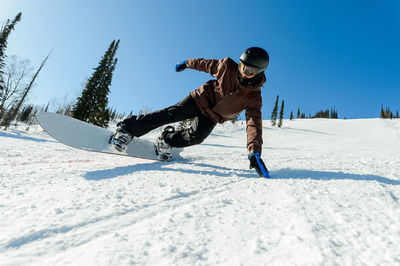 Rear view of man skiing on snow against sky