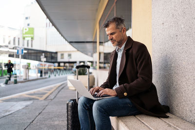 Full length of man using mobile phone