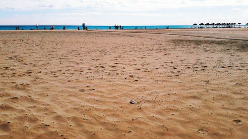 Scenic view of beach against cloudy sky