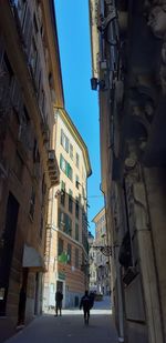 People walking on street amidst buildings in city