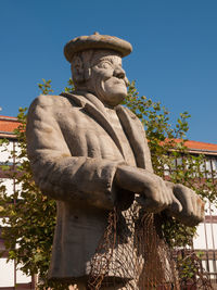 Low angle view of statue against clear blue sky