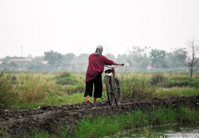 Rear view of woman walking on field