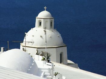 Church by sea against blue sky