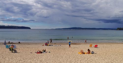 Scenic view of beach against cloudy sky