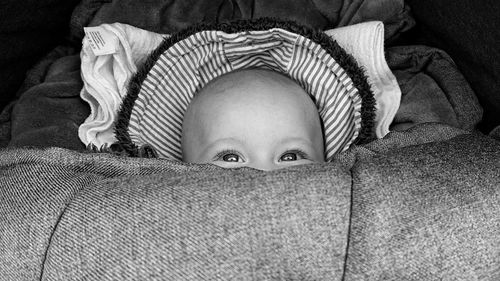 Close-up of cute baby girl relaxing on bed