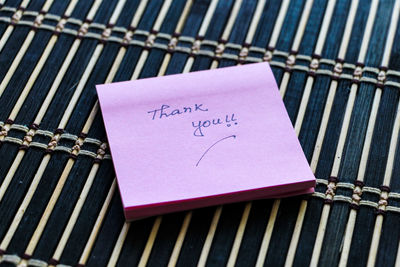 High angle view of thank you text on adhesive note