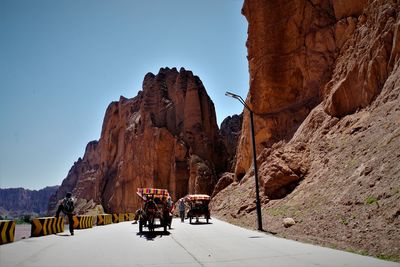 People on mountain road against clear sky