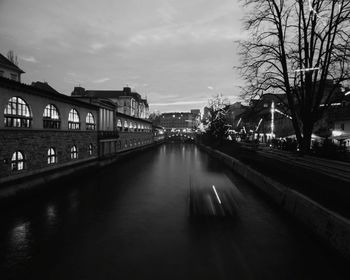 Illuminated bridge over river in city at night