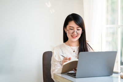 Smiling young woman using smart phone