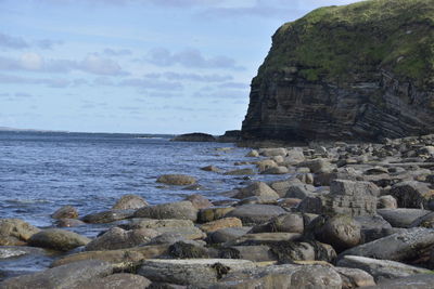Rocks on beach against sky