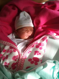 Portrait of cute baby girl sleeping on bed at home